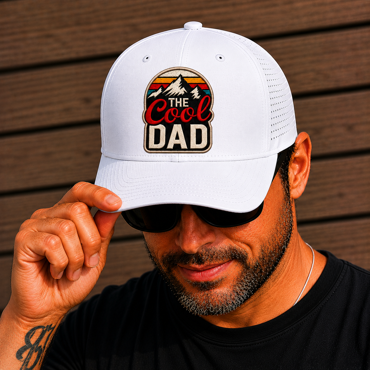 Man wearing a white cap with 'The Cool Dad' logo against a wooden background