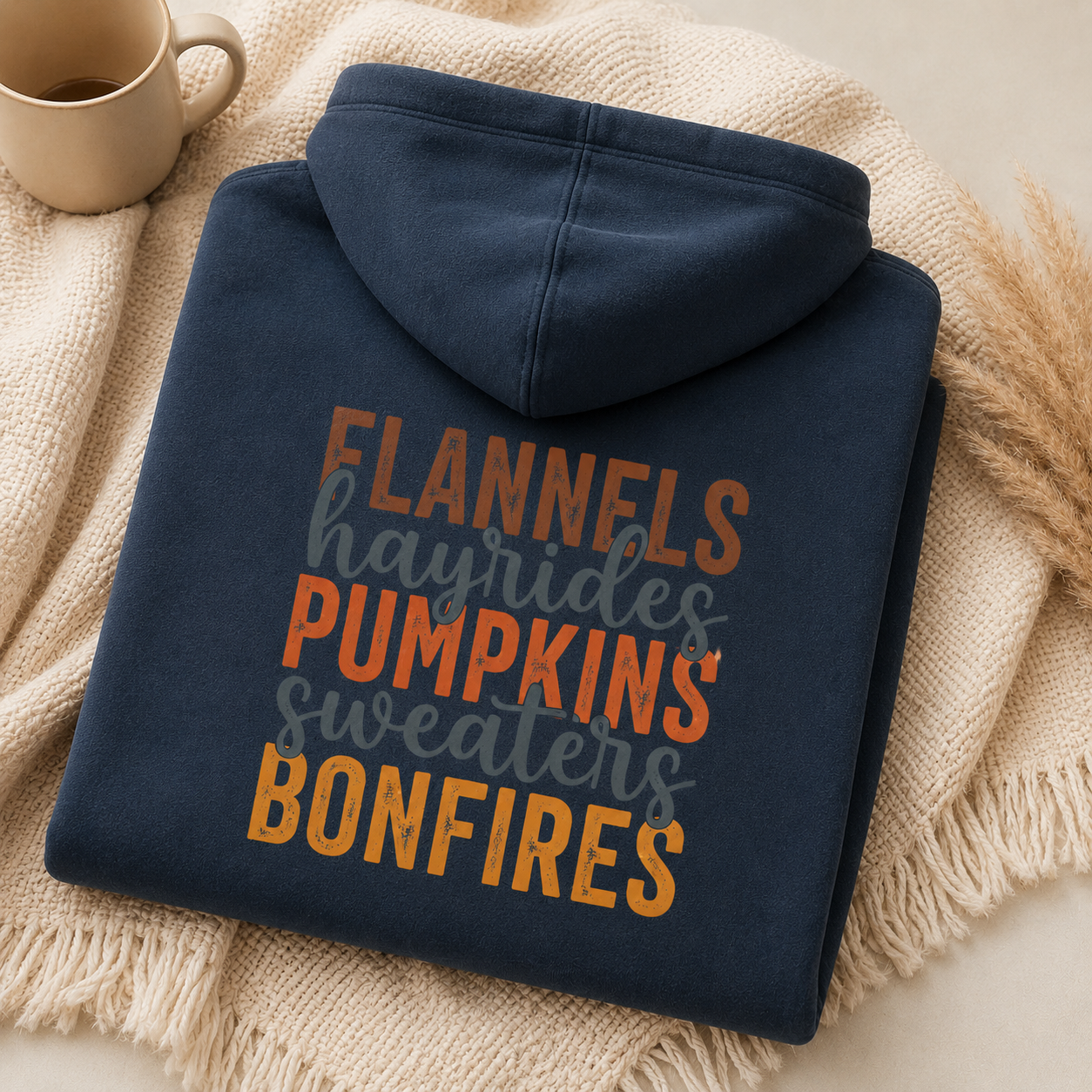 Folded Blue Dusk fall hoodie with Flannels, Hayrides, Pumpkins, Sweaters and Bonfires graphic printed on the back.