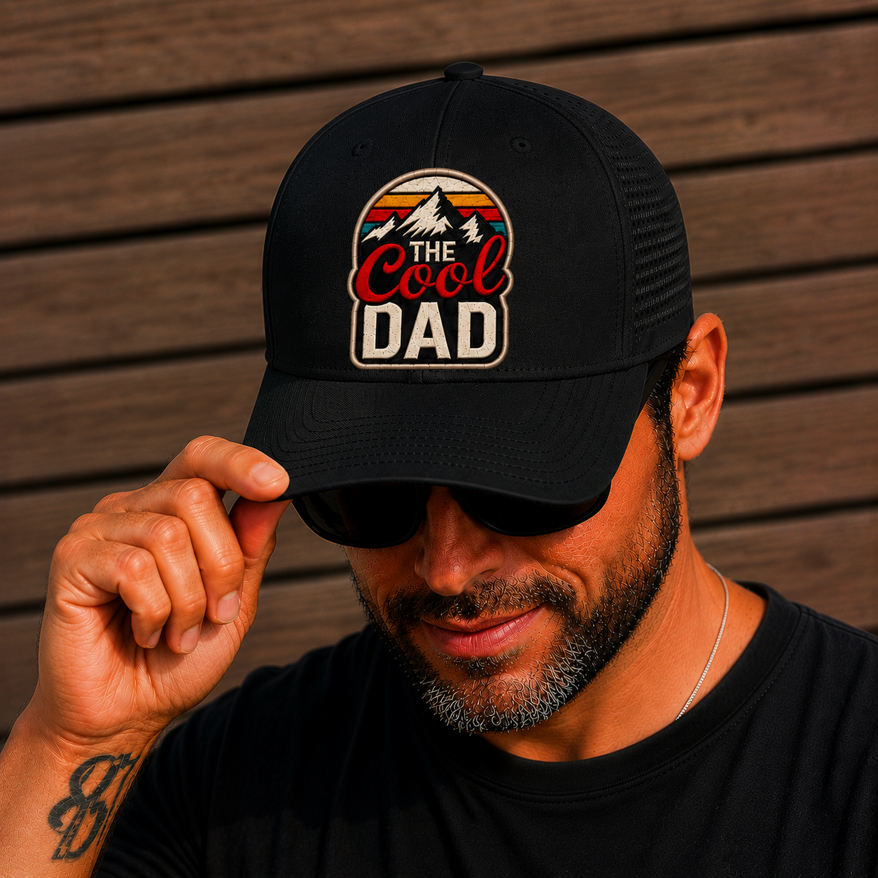 Man wearing a black cap with 'The Cool Dad' logo against a wooden background. The Scoobie Shack