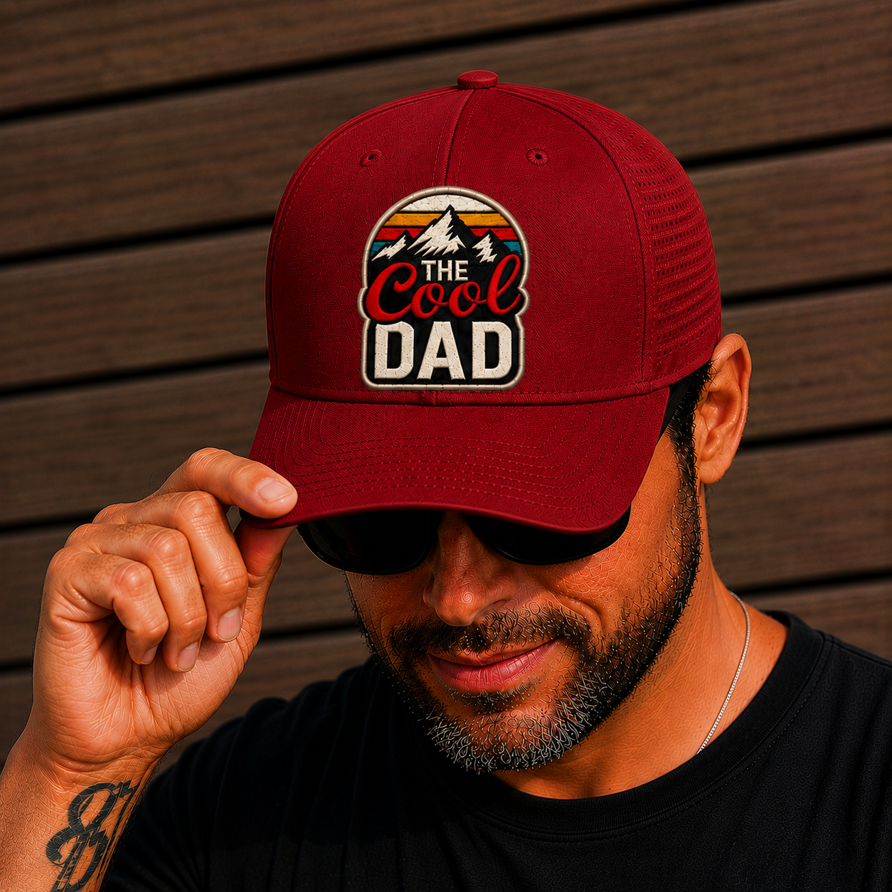 Man wearing a red cap with 'The Cool Dad' text against a wooden background