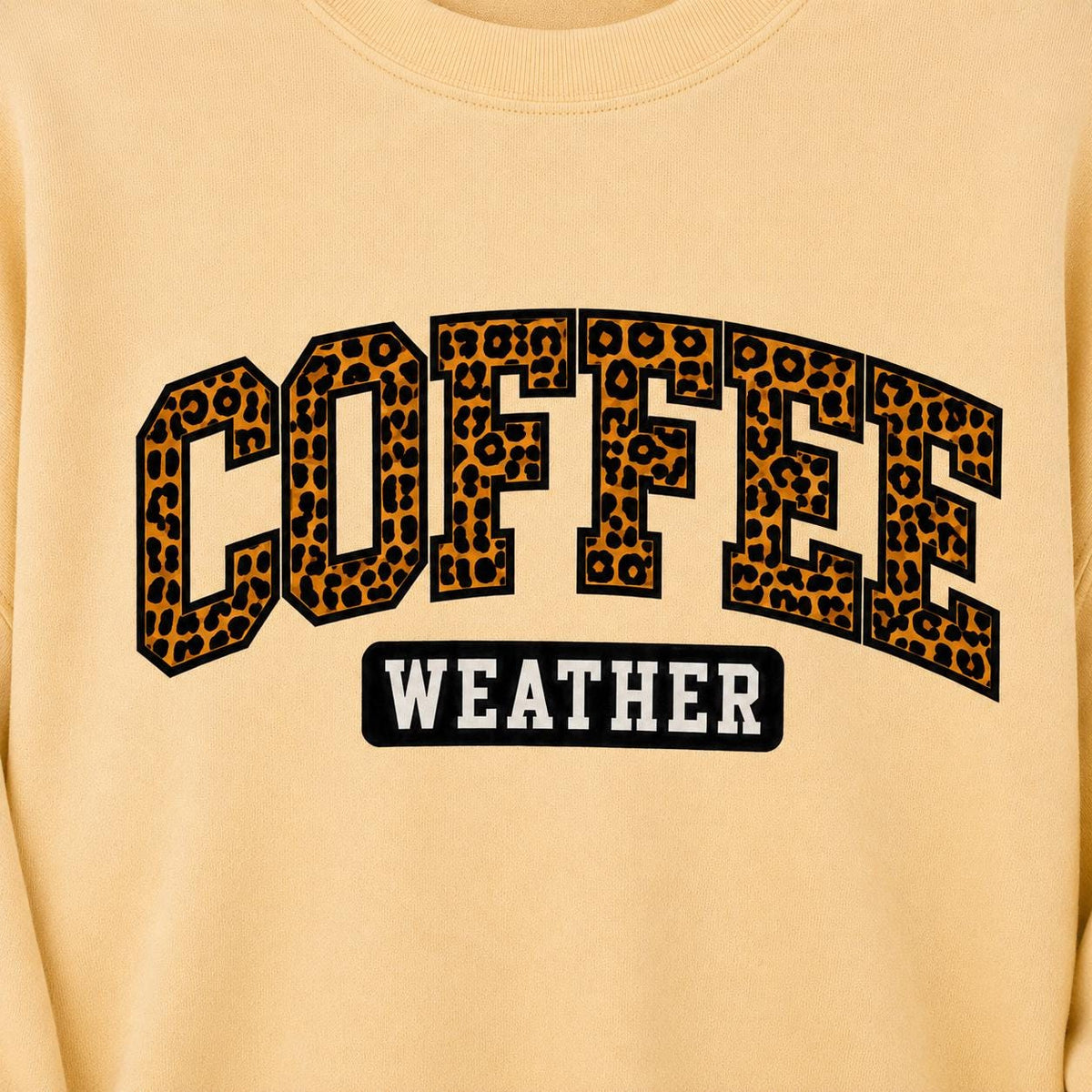 Close-up of Coffee Weather Sweatshirt featuring bold leopard print lettering on a Yellow Haze crewneck
