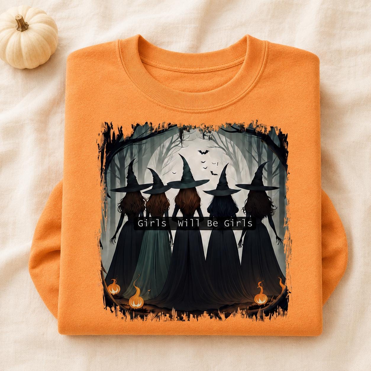 Folded orange Girls Will Be Girls Witch Sweatshirt with vintage Halloween witch graphic and pumpkin accents
