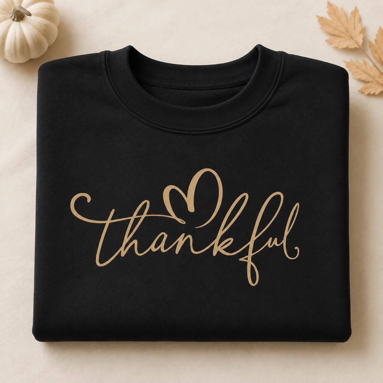 Use:

Folded black Thankful Sweatshirt with gold script heart design and fall pumpkin accents`
