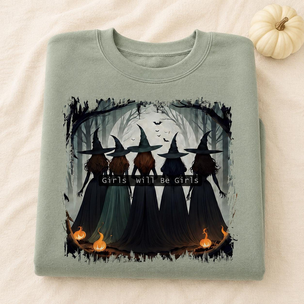 Folded sage Girls Will Be Girls Witch Sweatshirt with vintage Halloween witch graphic and pumpkin accents
