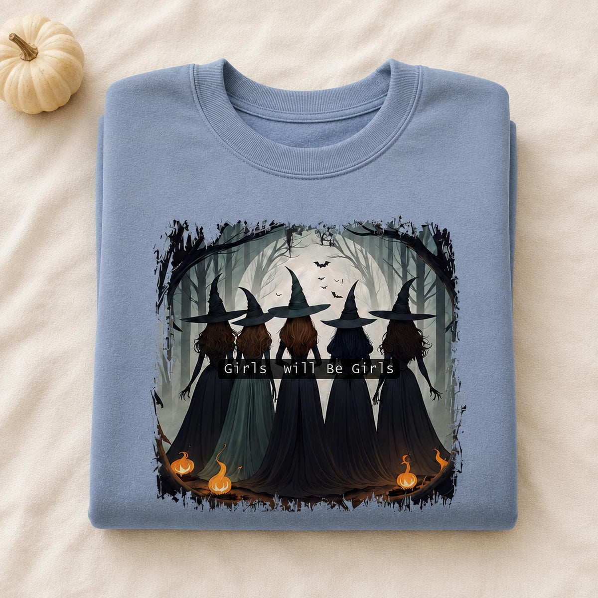 Folded light blue Girls Will Be Girls Witch Sweatshirt with vintage Halloween witch graphic and pumpkin accents
