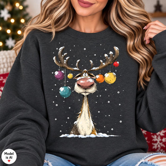 Woman wearing a Heather Black funny reindeer Christmas sweatshirt with colorful ornaments.