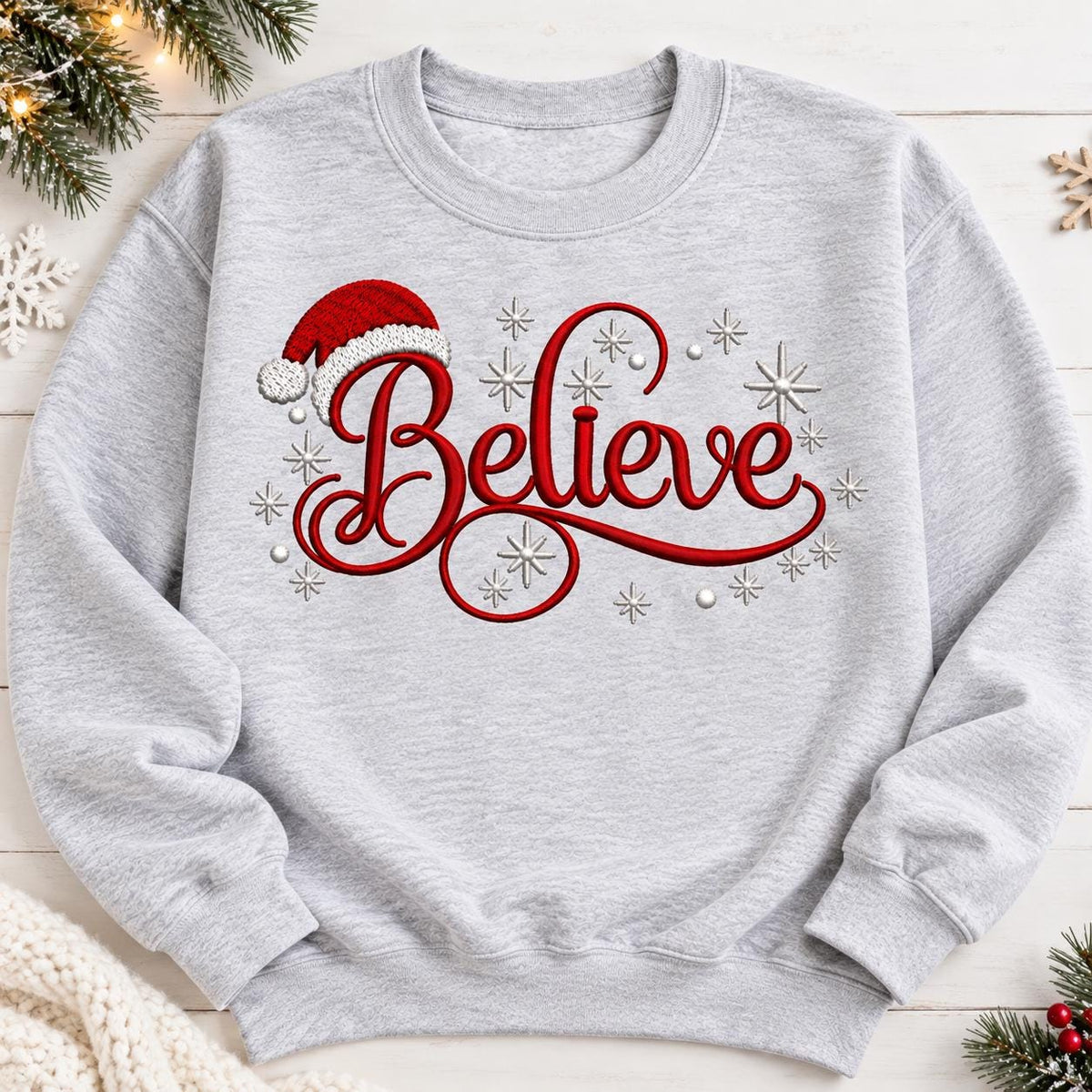 Ash Gray Believe Christmas sweatshirt laid flat with Santa hat design.