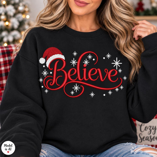 Woman wearing a black Believe Christmas sweatshirt with Santa hat and snowflake design.