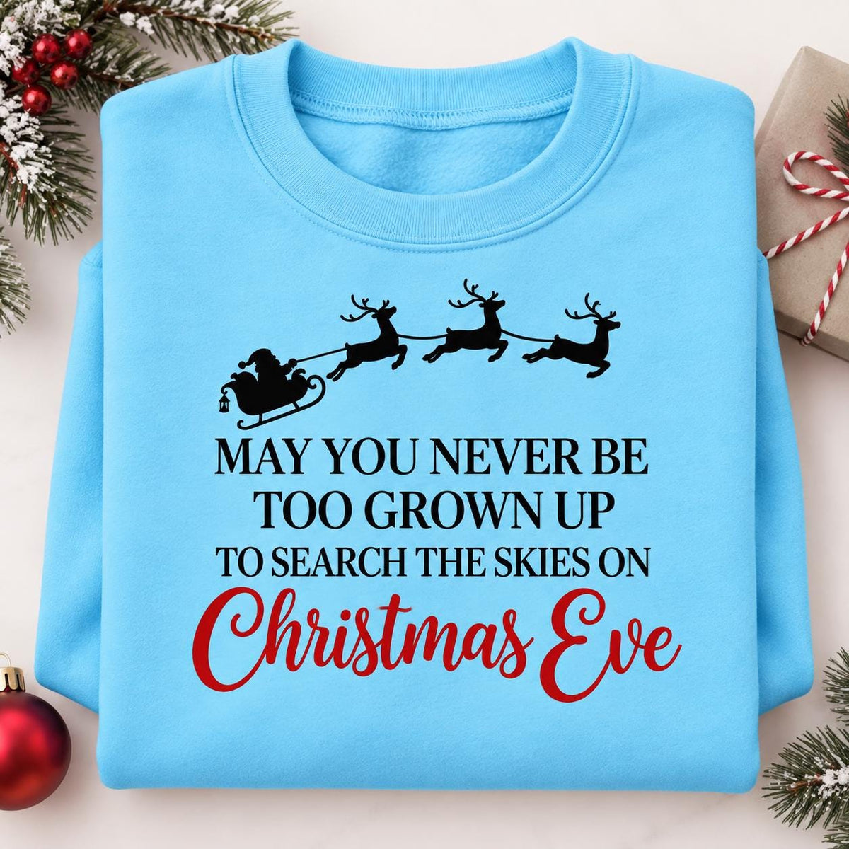 Folded Sky blue Santa sleigh sweatshirt with Christmas Eve quote.