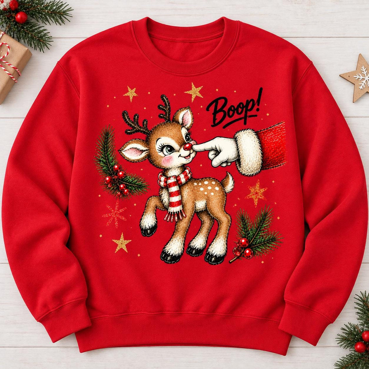Red Boop reindeer holiday sweatshirt laid flat with festive greenery.