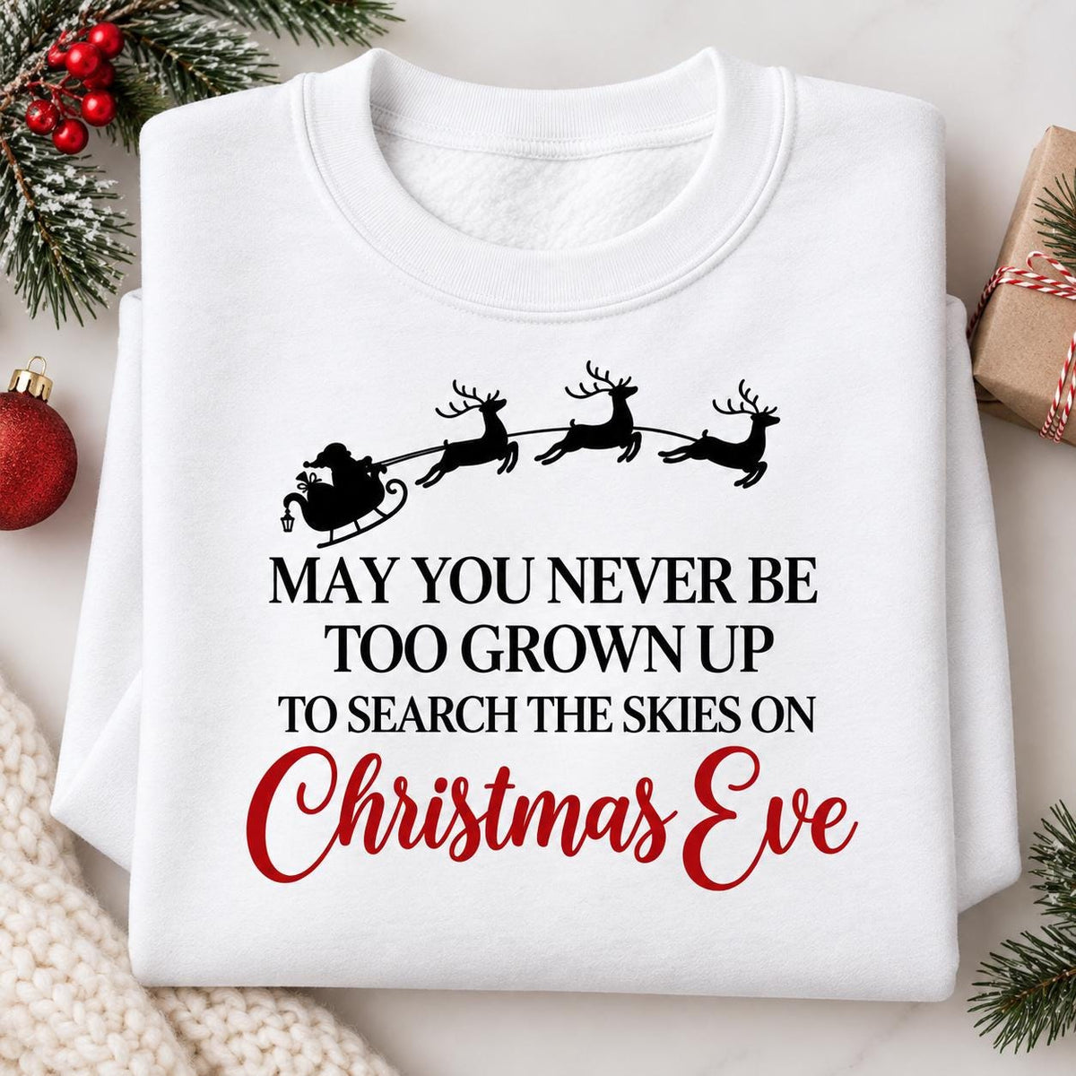 Folded white Christmas Eve sweatshirt with nostalgic Santa sleigh quote.