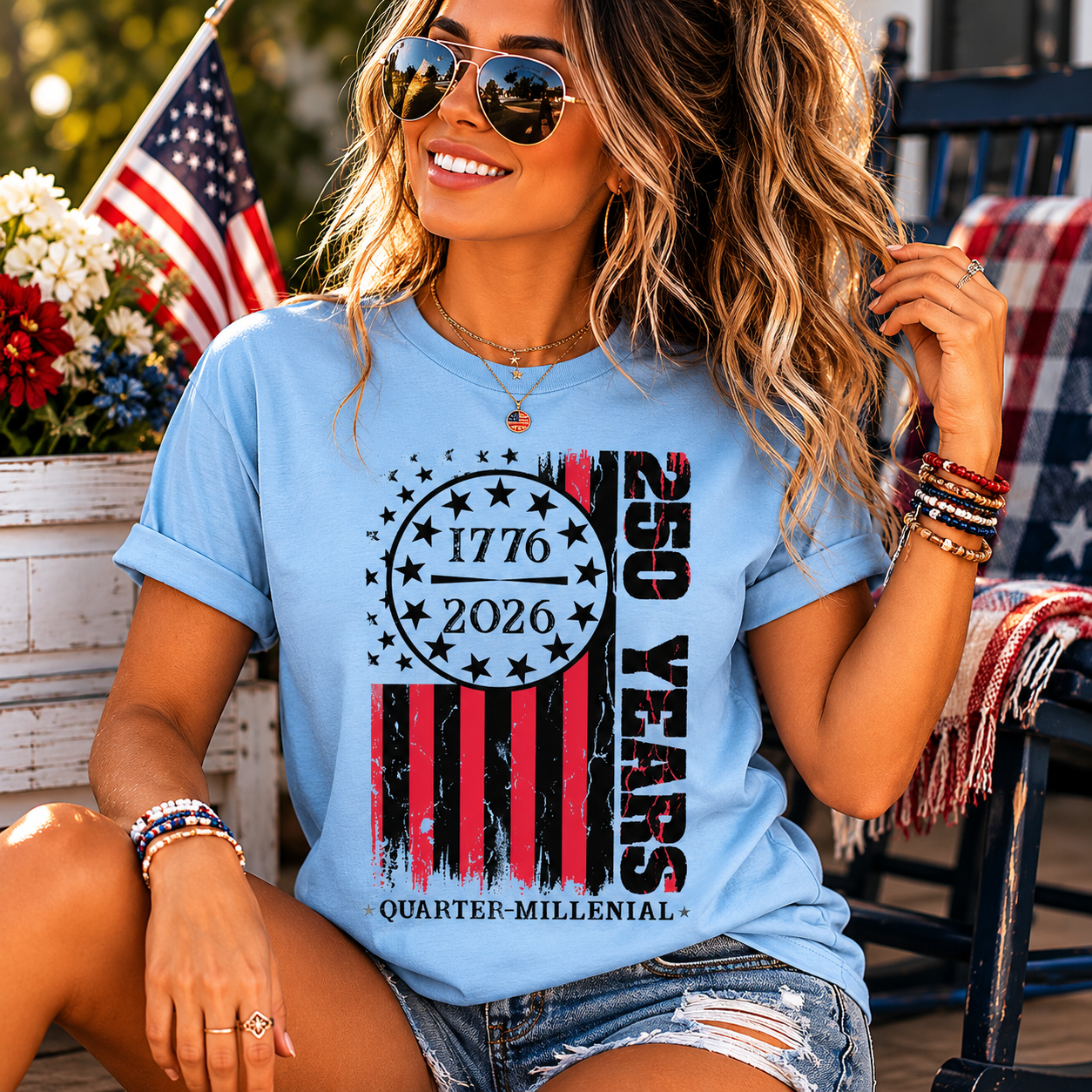 Woman wearing a blue t-shirt celebrating 250 years with American flag design, sitting outdoors.