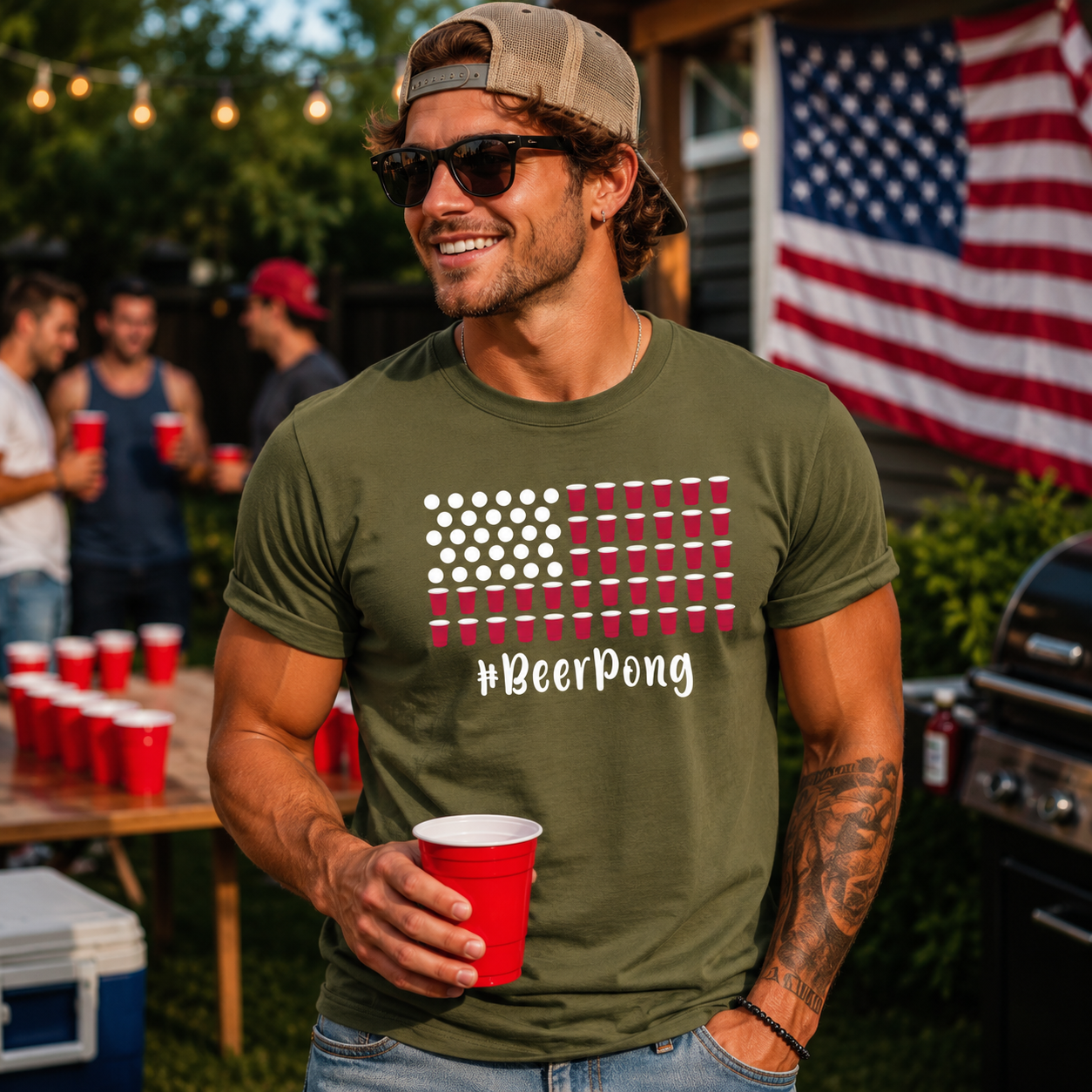 Man wearing a '#BeerPong' t-shirt holding a red cup outdoors with an American flag in the background.