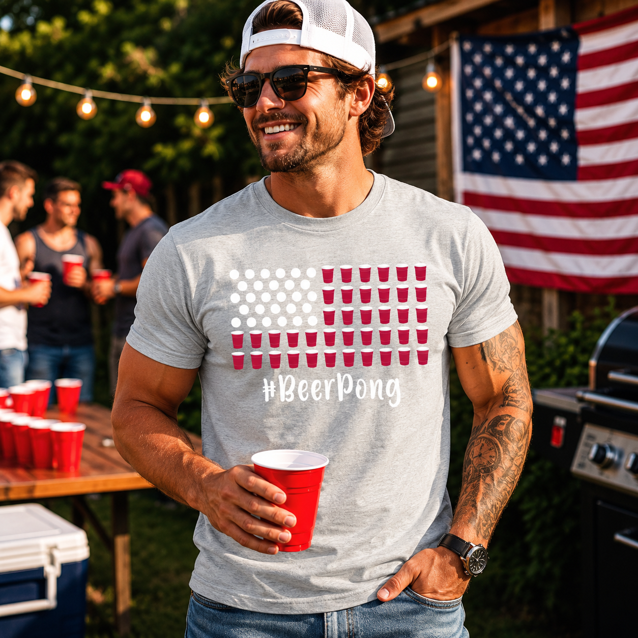 Man wearing a '#BeerPong' t-shirt holding a red cup outdoors with an American flag in the background.