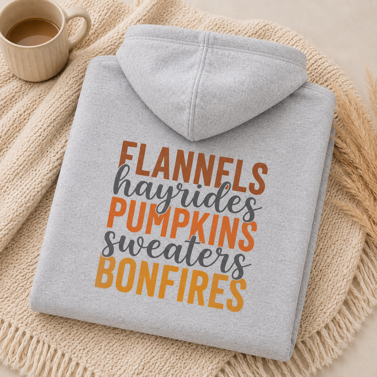 Folded Sport Gray fall hoodie with Flannels, Hayrides, Pumpkins, Sweaters and Bonfires graphic printed on the back.