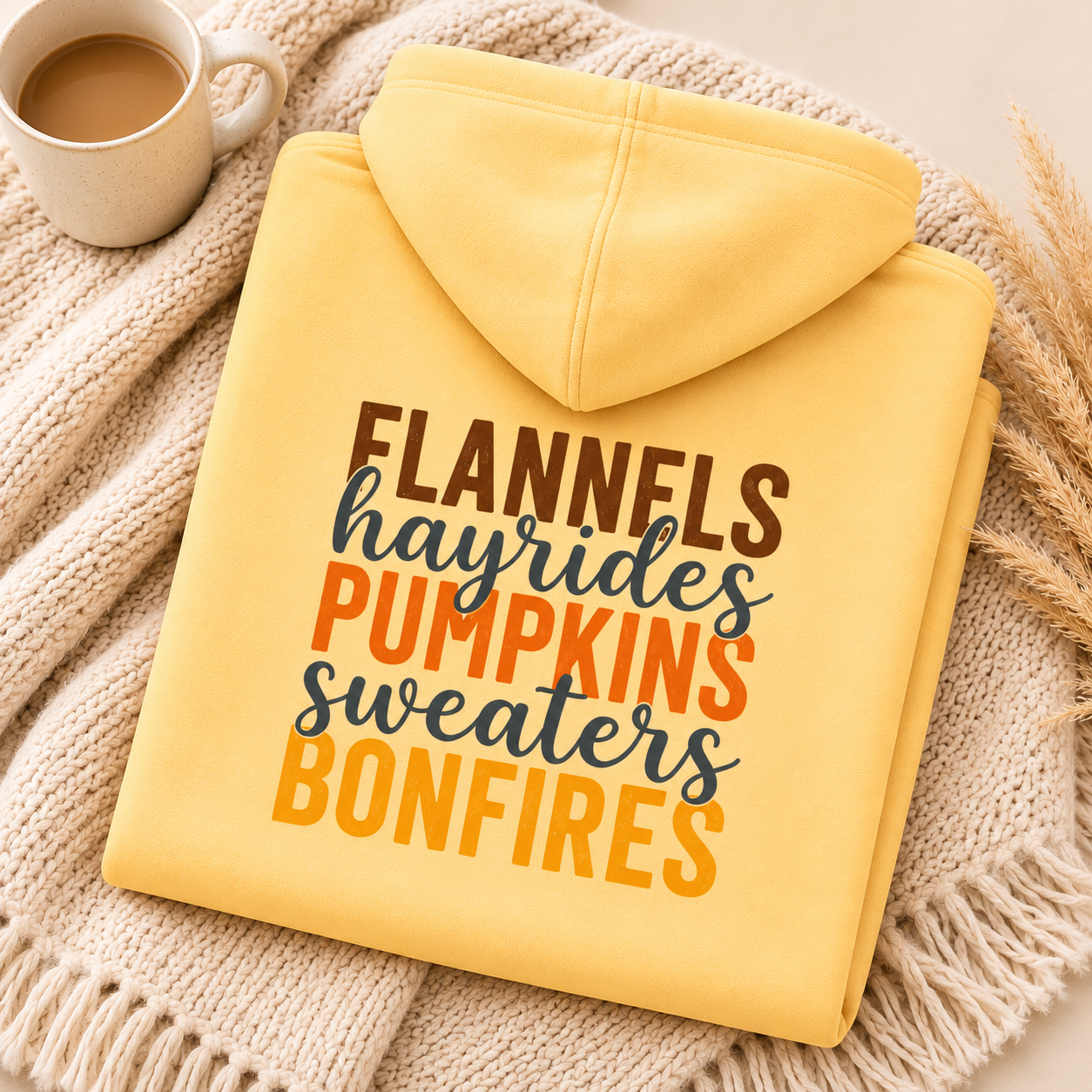 Folded Yellow Haze fall hoodie with Flannels, Hayrides, Pumpkins, Sweaters and Bonfires graphic printed on the back.